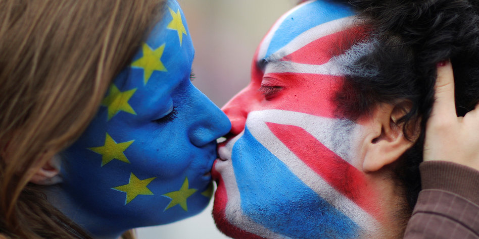 Two activists with the EU flag and Union Jack painted on their faces kiss each other in front of Brandenburg Gate to protest against the British exit from the European Union, in Berlin, Germany, June 19, 2016. REUTERS/Hannibal Hanschke TPX IMAGES OF THE DAY